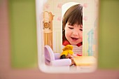 Little girl playing with dolls' house