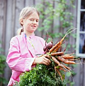 A girl holding carrots, Sweden.