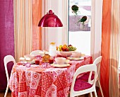 Gedeckter Frühstückstisch in Pink und Orangetönen