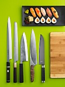 Maki- und Nigiri-Sushi; davor funf Messer aus Edelstahl