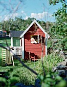 Little girl in wooden Wendy house