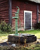 A Water Pump in front of a Barn