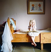 Portrait of a blond girl sitting in a bed, Sweden