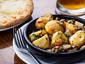 Georgian cuisine – potatoes with mushrooms baked on a clay pot.