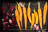 Carrots, garlic and beetroot on a baking tray