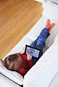 Boy on sofa using digital tablet