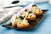 Grilled bread topped with scrambled eggs, onions, chives and caviar
