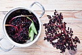 Elderberries in a pan and to one side