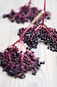 Elderberries on a wooden surface (close-up)