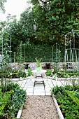 Symmetrically arranged vegetable beds with small, trophy-shaped fountains in background