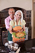 An older couple with a freshly baked pie in the kitchen