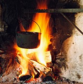 Heidelbeeren kochen in einem Kessel am Lagerfeuer