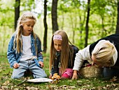 Mother and daughters picking mushrooms in forest