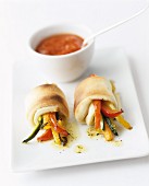 Pan-fried vegetable batons wrapped in dough, with a tomato sauce