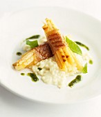 Grilled white asparagus wrapped in ham, on risotto