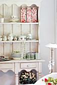 Crockery and ceramic vessels in rustic dresser with open-fronted top