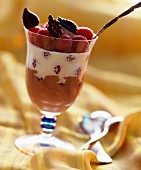 A layered dessert of cream, chocolate mousse and raspberries