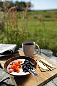 Frühstück im Freien mit Beerenmüsli, Knäckebrot und Kaffee
