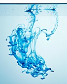 Blaue Tinte tropft ins Wasser