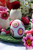 Oster-Tischdekoration mit frischen Blüten und Ei verziert mit Serviettentechnik