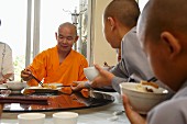 Essende Mönche in einem chinesischen Kloster