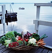 Korb mit verschiedenen Gemüsesorten auf Bootssteg