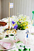 Table set with vase of flowers & Swedish flag