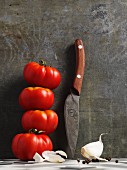 Beef tomatoes with a sharp knife and a clove of garlic