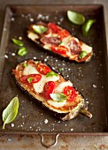 Aubergine halves topped with tomatoes and cheese and baked