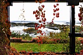 View through climber-covered veranda pillars into autumnal garden on Norwegian skerry coast