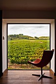 Designer Drehsessel vor Panoramafenster in einer Wandnische mit Blick auf französische Landschaft mit Weinfeldern