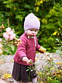 Kleines Mädchen erkundet Blumen im Garten