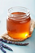 A jar of honey and lavender flowers