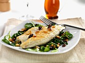 pan fried sea bass with wilted spinach, roasted pine nuts and sultanas