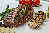 Grilled beef steak with herb butter and vegetables