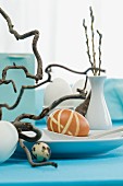 An Easter table decoration with eggs and corkscrew willow