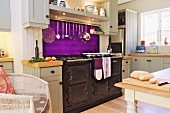 weiße Küche im Landhausstil mit leuchtend violettem Spritzschutz und großem Herd mit Metallfront