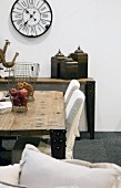 Rustic table and chairs with white loose covers; antique station clock on wall