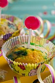 A muffin with green colouring and a lollipop (for a birthday or New Year)