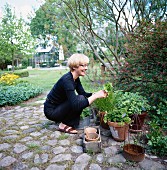 Hockende Frau bei der Gartenarbeit