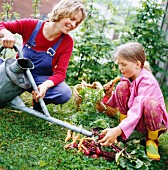 Mutter und Tochter mit frisch geerntetem Gemüse