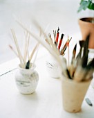 Pens and paintbrushes in jars.