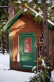 Mountain hut in snow with snow shoes & paddles hanging either side of door