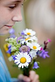 Girl holding posy of wild flowers (close-up)