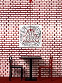 Table and chairs against red and white patterned wall