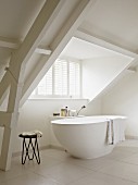 Minimalistisches Badezimmer mit freistehender Badewanne und langem Dachgaubenfenster
