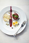 Beef tartare with beetroot purée, crispy coated quail's egg and truffle oil