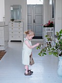 Kleines Mädchen betrachtet Blumenstrauss im Hausflur