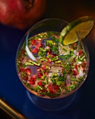 Pomegranate drink with vodka, herbs and lime