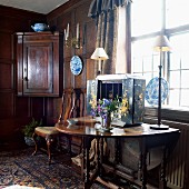 Ornaments on console table in renovated period interior with dark wood panelling